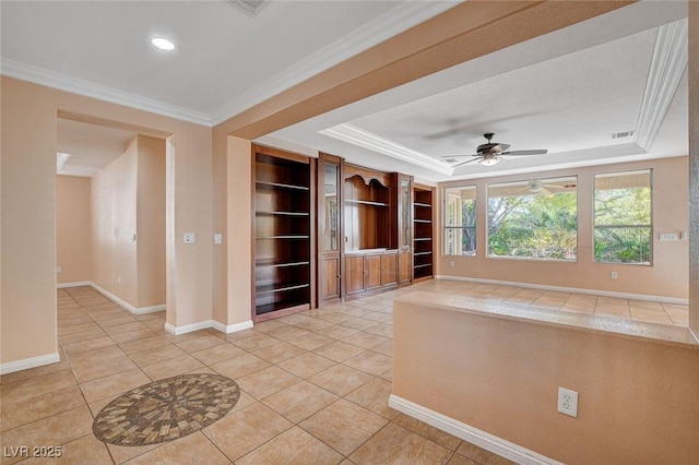 unfurnished living room featuring a tray ceiling, ceiling fan, light tile patterned floors, and ornamental molding