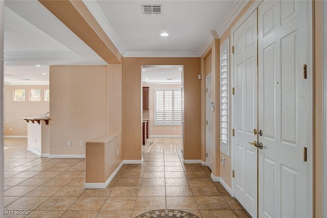 hallway featuring crown molding and light tile patterned floors