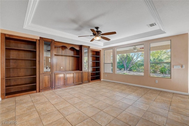 unfurnished living room with ornamental molding, built in shelves, a textured ceiling, a raised ceiling, and light tile patterned floors