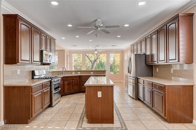 kitchen with backsplash, crown molding, light tile patterned floors, a kitchen island, and stainless steel appliances