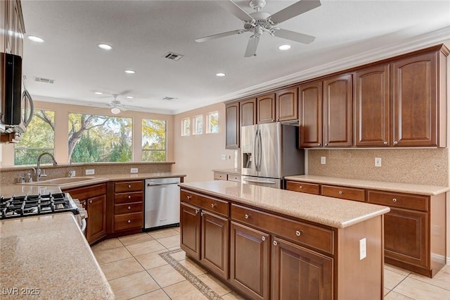 kitchen with stainless steel appliances, crown molding, sink, light tile patterned floors, and a center island