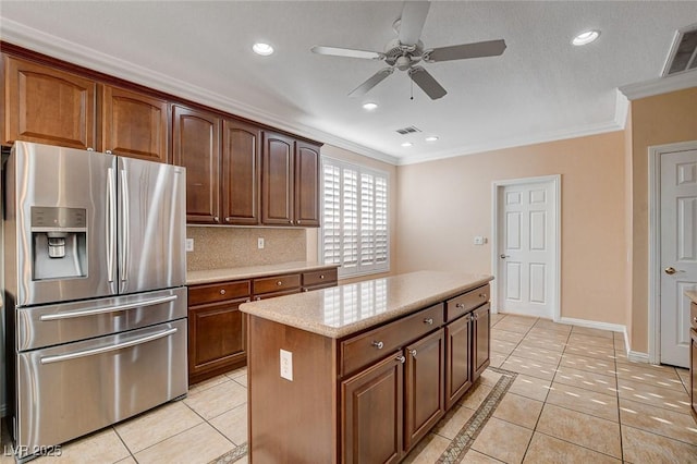 kitchen with crown molding, light tile patterned flooring, and stainless steel refrigerator with ice dispenser