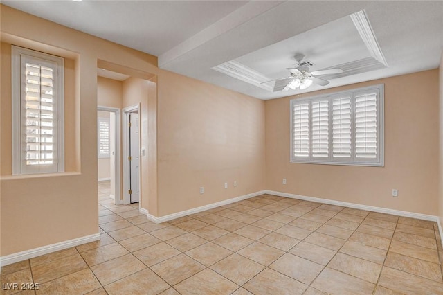 tiled spare room featuring a tray ceiling, ceiling fan, and crown molding