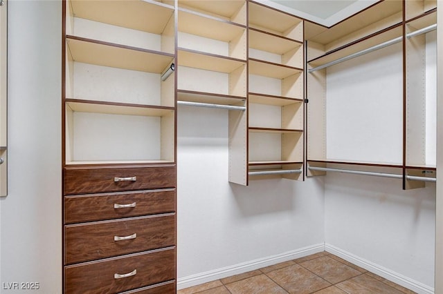 walk in closet with light tile patterned floors