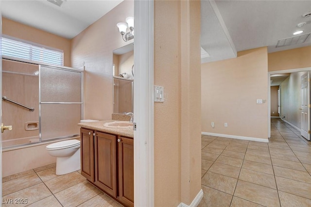 full bathroom with tile patterned floors, vanity, bath / shower combo with glass door, and toilet