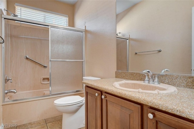 full bathroom featuring shower / bath combination with glass door, vanity, toilet, and tile patterned flooring