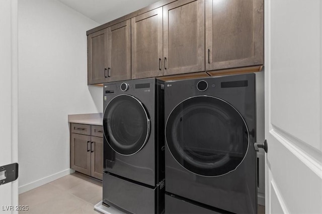 laundry room featuring cabinets, independent washer and dryer, and light tile patterned floors