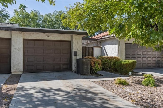 garage with central AC and concrete driveway