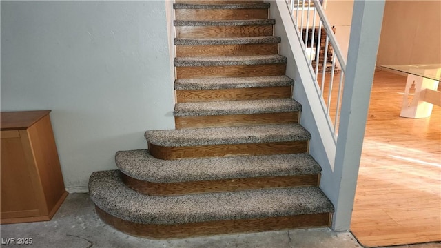 staircase with hardwood / wood-style floors