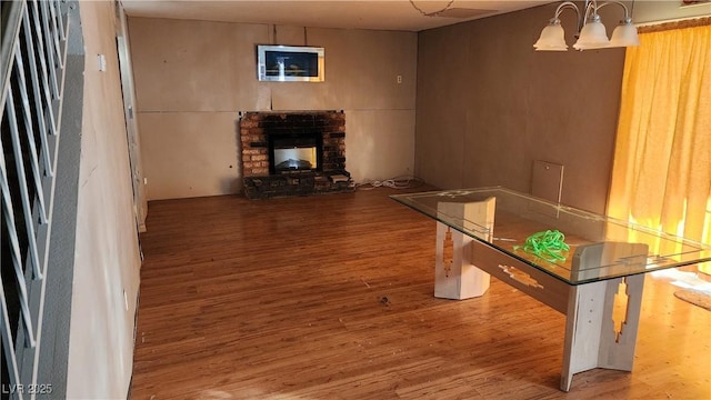 interior space with wood-type flooring, a fireplace, and a chandelier