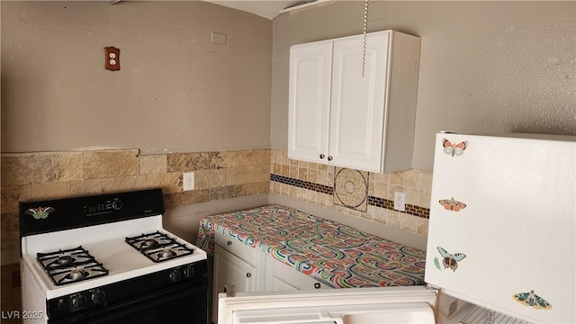 kitchen featuring white cabinetry, gas stove, and decorative backsplash