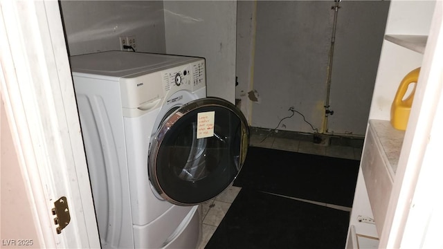 laundry area featuring washer / dryer and tile patterned flooring