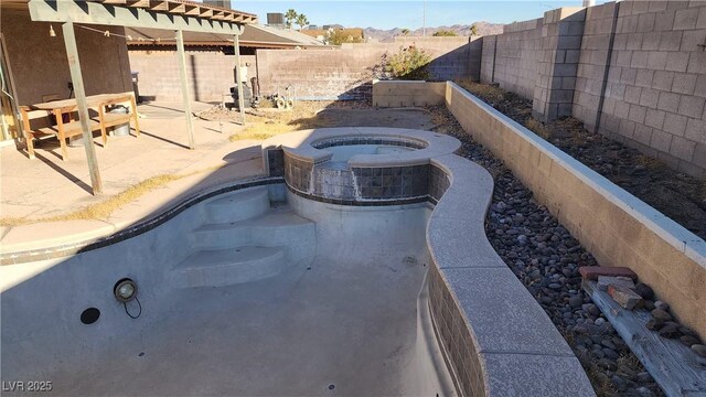 exterior space featuring an in ground hot tub and a patio