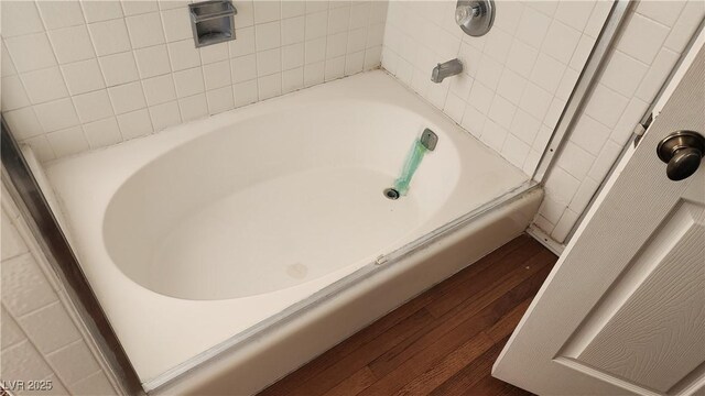 bathroom featuring wood-type flooring and a tub