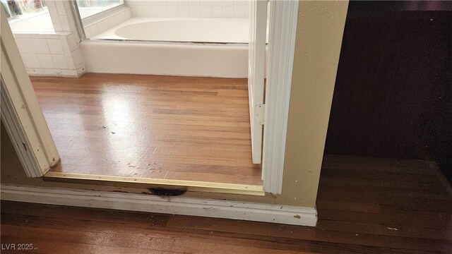 bathroom with hardwood / wood-style floors and a bath