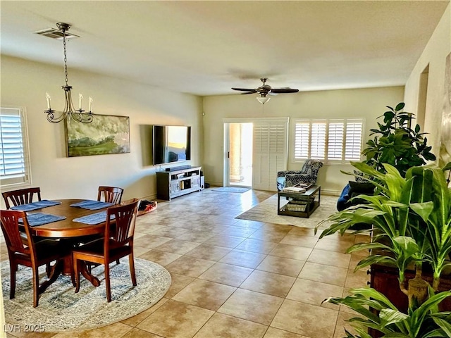 dining room with light tile patterned flooring and ceiling fan with notable chandelier