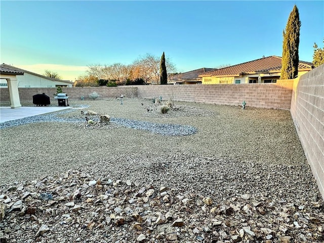 yard at dusk featuring a patio area