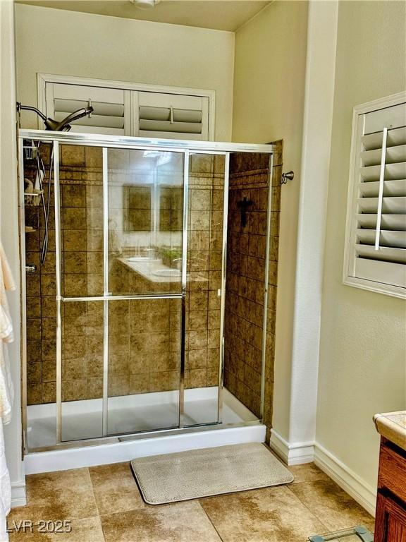 bathroom with tile patterned flooring, vanity, and a shower with door