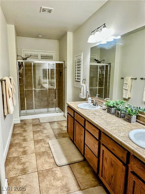 bathroom featuring tile patterned flooring, vanity, and an enclosed shower