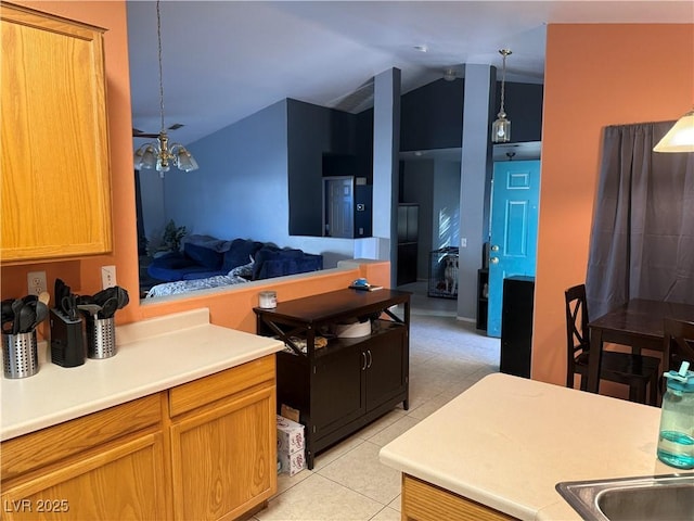 kitchen with light tile patterned floors, open floor plan, hanging light fixtures, vaulted ceiling, and light countertops