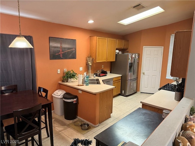 kitchen with light tile patterned floors, stainless steel appliances, light countertops, visible vents, and a peninsula