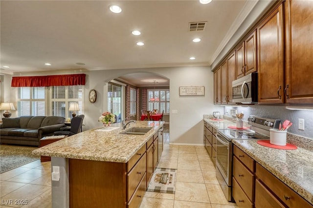 kitchen featuring light stone countertops, sink, stainless steel appliances, an island with sink, and light tile patterned floors