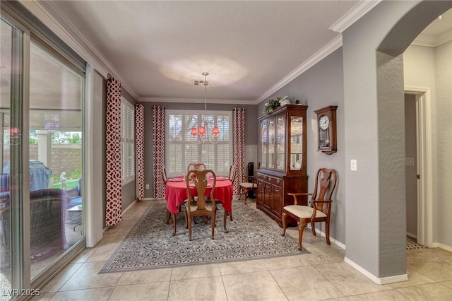 dining room featuring a notable chandelier, ornamental molding, and light tile patterned floors