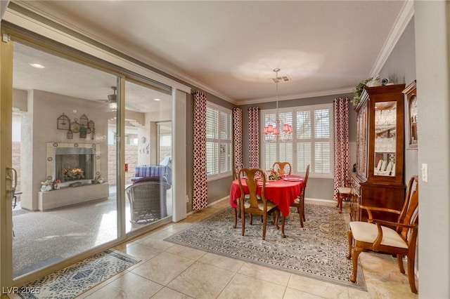 tiled dining space featuring crown molding and an inviting chandelier