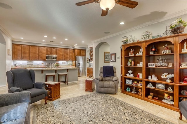 living room featuring light tile patterned floors, ceiling fan, and crown molding