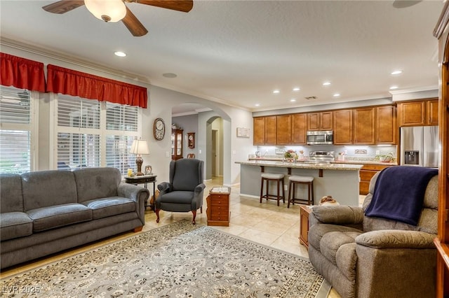 living room with crown molding, ceiling fan, and light tile patterned flooring