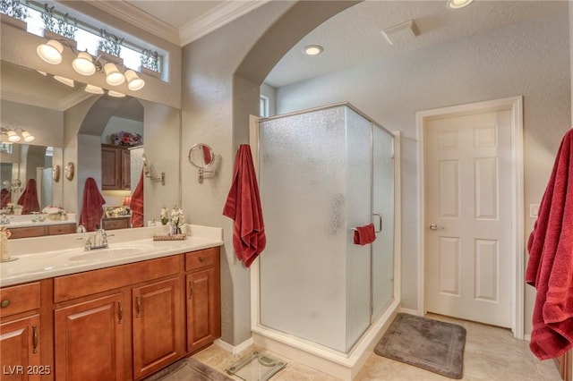 bathroom featuring vanity, tile patterned floors, an enclosed shower, and crown molding