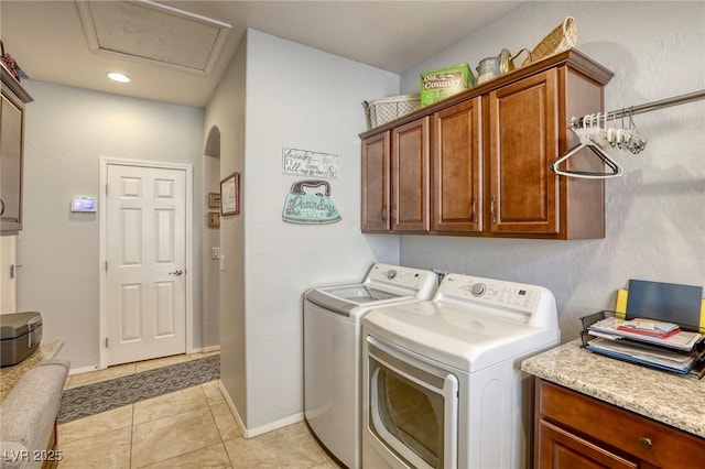 laundry room featuring cabinets, independent washer and dryer, and light tile patterned floors