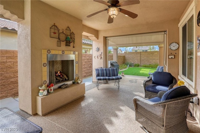 exterior space featuring a tiled fireplace and ceiling fan