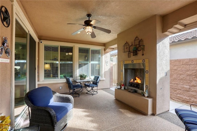 view of patio / terrace with ceiling fan and exterior fireplace