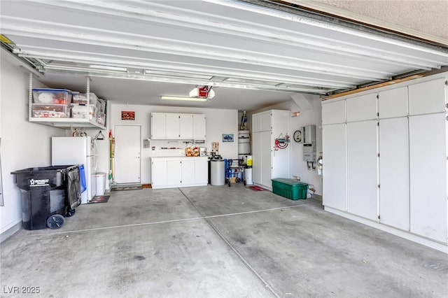 garage with secured water heater, white fridge, and a garage door opener