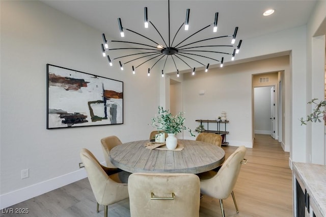 dining room with a chandelier and light hardwood / wood-style floors