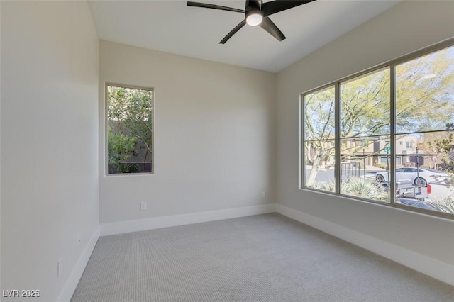 empty room featuring carpet flooring, ceiling fan, and a healthy amount of sunlight