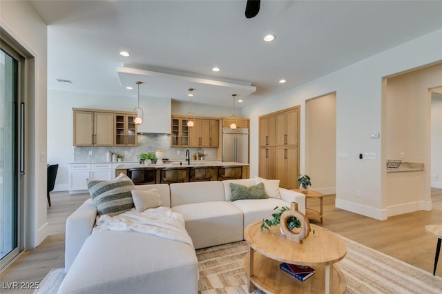 living room featuring light wood-type flooring and sink