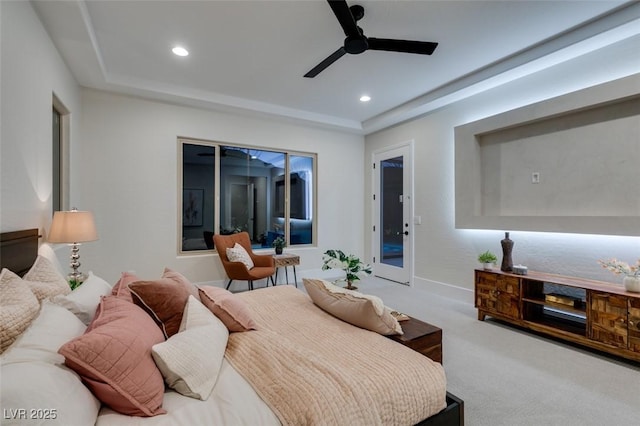 carpeted bedroom with access to outside, a raised ceiling, and ceiling fan