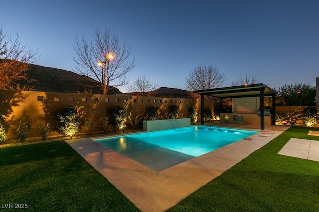 pool at dusk with a lawn and a mountain view