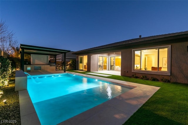 view of pool with a patio area, pool water feature, and a yard