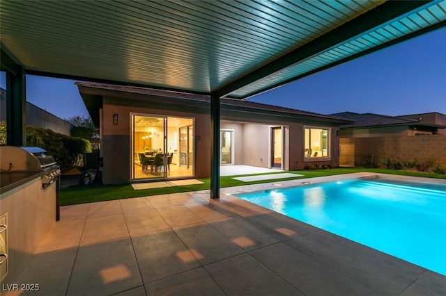 view of pool with an outdoor kitchen, area for grilling, and a patio