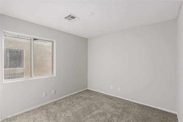 empty room featuring visible vents, baseboards, and carpet floors