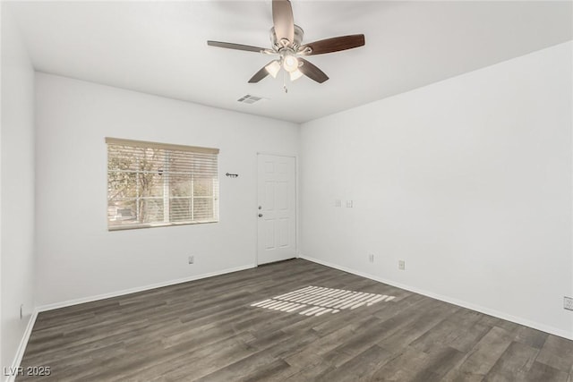 spare room featuring visible vents, ceiling fan, baseboards, and wood finished floors