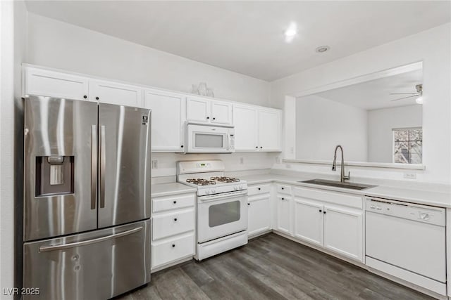 kitchen with a sink, white appliances, white cabinets, and light countertops