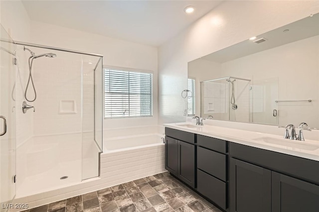 bathroom with vanity and shower with separate bathtub