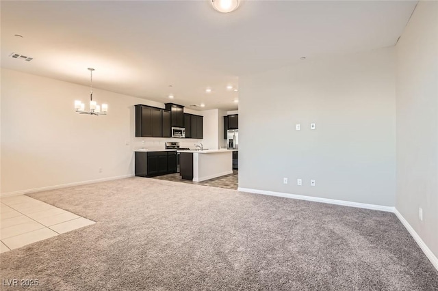 unfurnished living room with carpet flooring and a notable chandelier