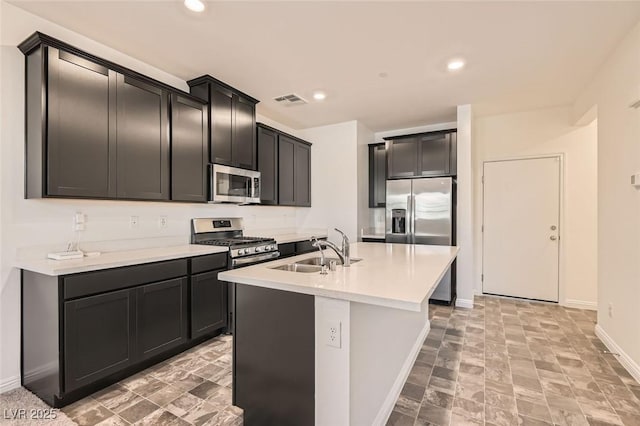 kitchen featuring a kitchen island with sink, sink, and stainless steel appliances