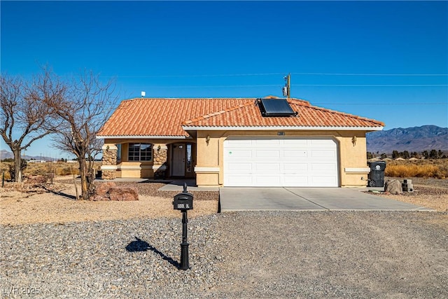 view of front of property with a mountain view and solar panels