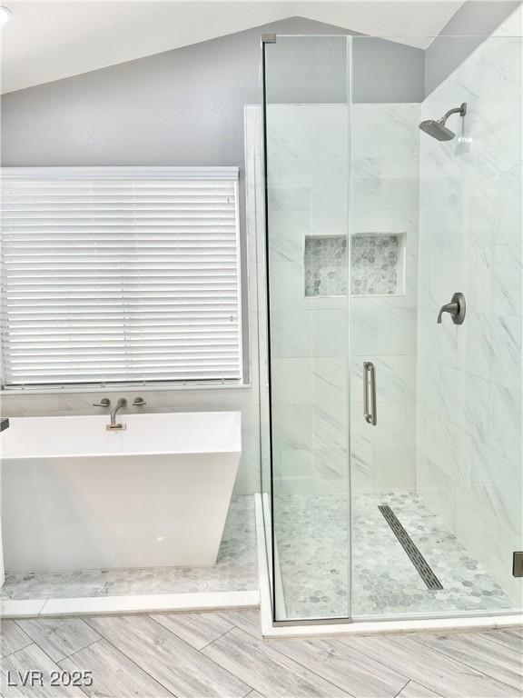 bathroom featuring lofted ceiling and plus walk in shower